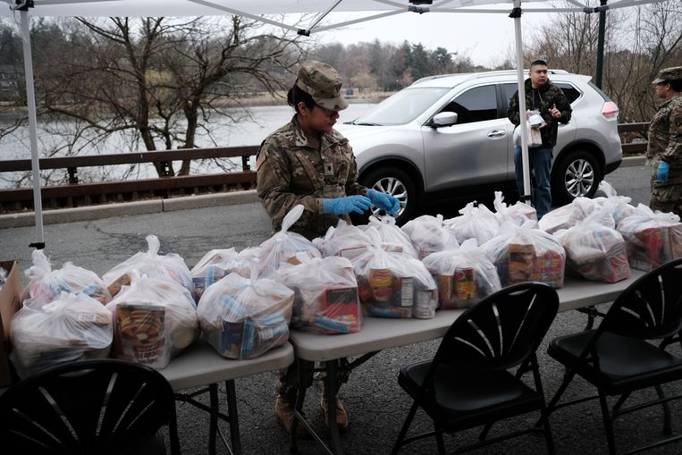 De National Guard deelt voedselpakketten uit aan bewoners van New Rochelle, waar veel bewoners zijn getroffen door het coronovirus.   Beeld Getty Images