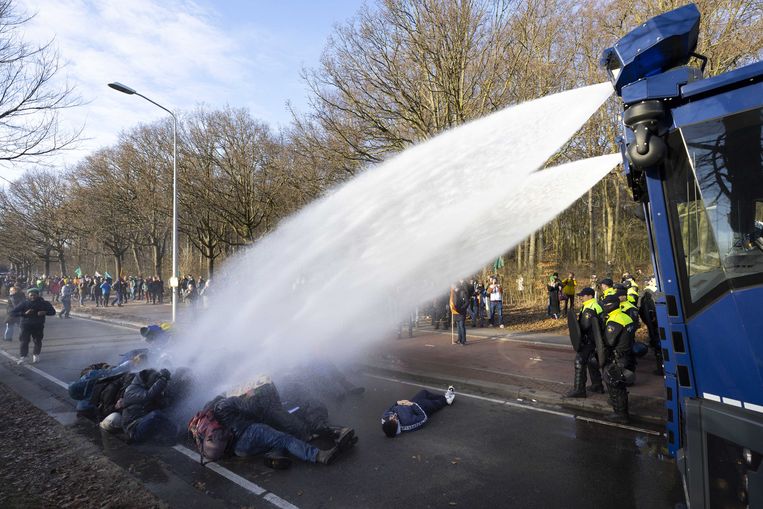 De politie zet het waterkanon in tegen actievoerders van Extinction Rebellion (XR) die zaterdag de Utrechtsebaan blokkeerden. Beeld ANP