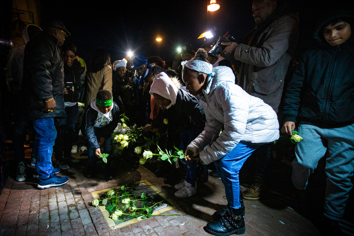 Moeder, overige familie en vrienden leggen bloemen bij de gedenksteen voor rapper Bolle. Beeld Maarten Brante