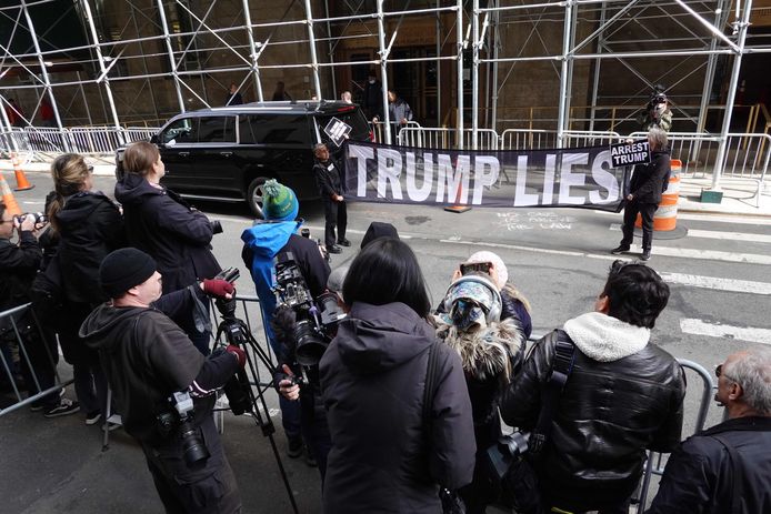 Tegenstanders van Trump aan het gebouw.
