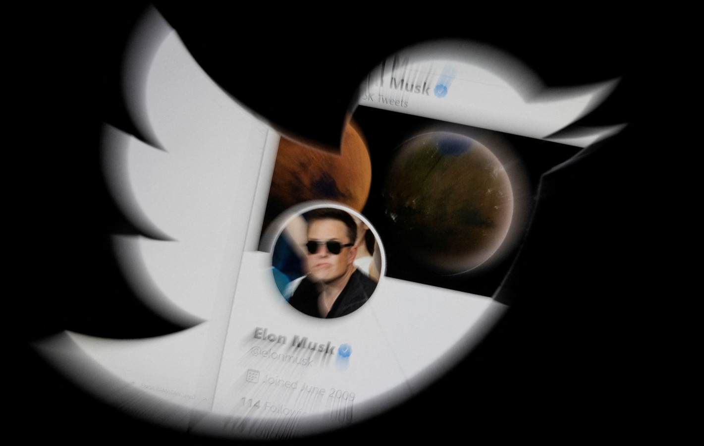 Het Twitter-account van Elon Musk gezien door het Twitter-logo heen.