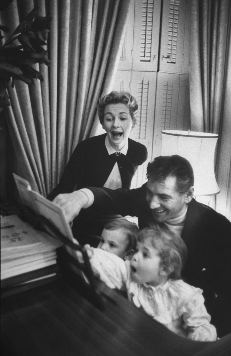 Leonard Bernstein met Felicia Montealegre en hun kinderen Alexander (l.) en Jamie (r.) thuis achter de piano, in 1956. Beeld Getty