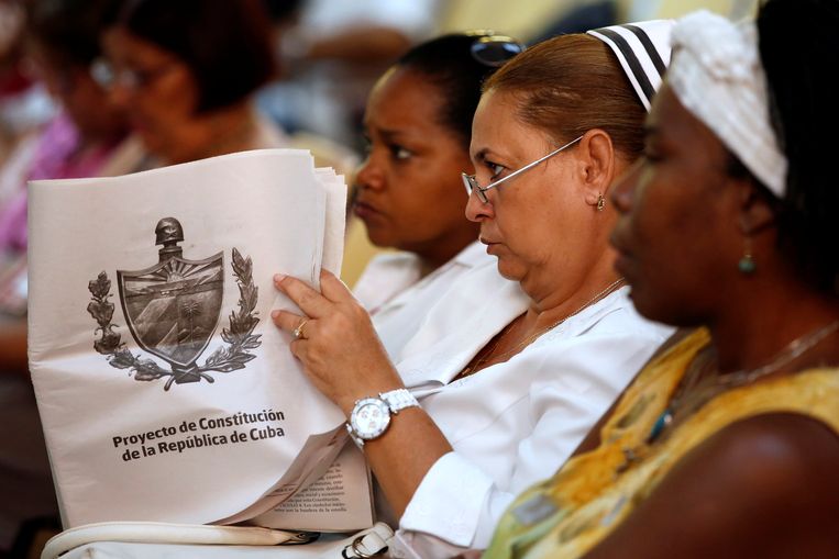 Een Cubaanse verpleegkundige bekijkt de conceptgrondwet bij een bijeenkomst in een kliniek in Havana, 13 augustus. Beeld Reuters