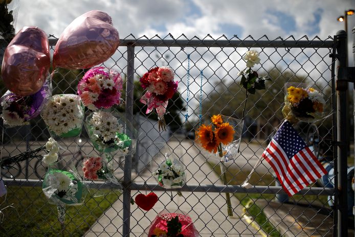 Bloemen, ballonnen en een Amerikaanse vlaggetje hangen aan de schoolpoort van de school waar een student vorige maand in Florida een bloedbad aanrichtte.