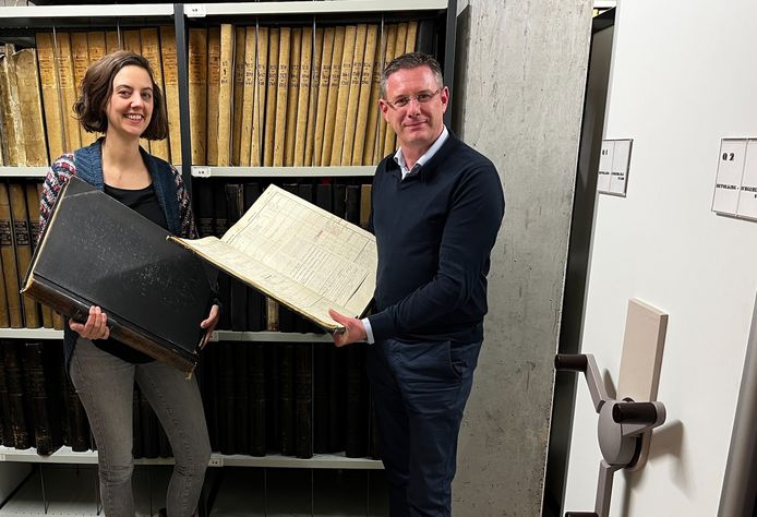 Cultuurschepen Kurt Himpe en	
Coördinator intergemeentelijk archiefteam Karen Derycke bij één van de boeken die gerestaureerd worden.