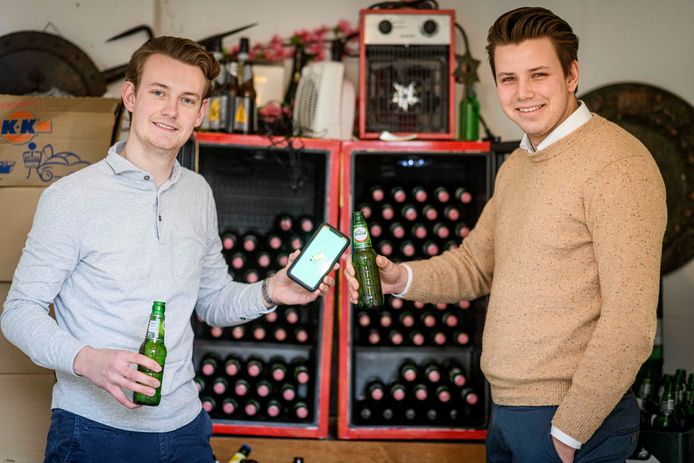 Xander Bon (L) en Marnick Van der Arend, bewoners van studentenhuis Asgard met de nieuw app die de voorraad bijhoudt en opslaat wie er wat heeft gebruikt.