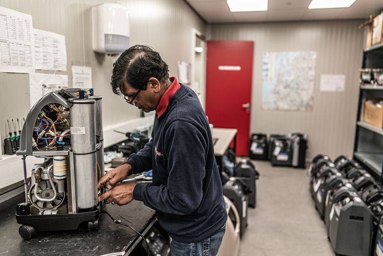 Een medewerker van Air Liquide Healthcare  in Lelystad controleert en repareert een zuurstofconcentrator. Beeld Joris van Gennip