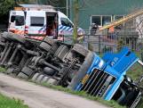 Vrachtwagen kiepert om en belandt op z'n kop in de sloot