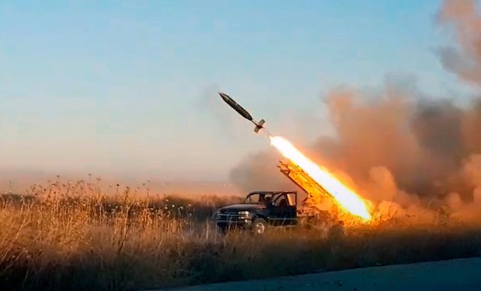 Strijders van Hayat Tahrir al-Sham (HTS) schieten een projectiel af op posities van het Syrische leger bij Khan Sheikhoun in de regio Idlib.
