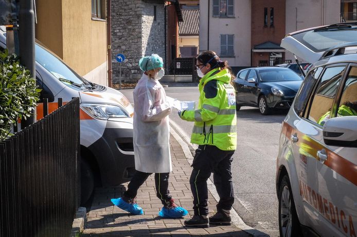 Gezondheidsmedewerkers komen iemand ophalen die vermoedelijk besmet raakte met het nieuwe coronavirus in Nembro, nabij Bergamo.