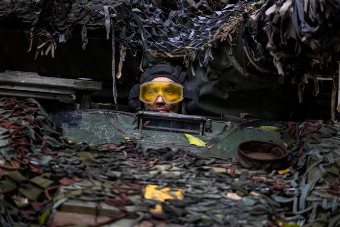 Close-upbeeld van bovenstaande foto. Een Oekraïense mechanicien maakt een testrit met een gerepareerde Russische tank in een bosgebied buiten Charkiv. Beeld van 26 september.