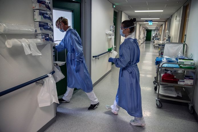 Verpleegkundigen met tegen corona beschermende kleding op een afdeling in het Nijmeegse Canisius-Wilhelmina Ziekenhuis.