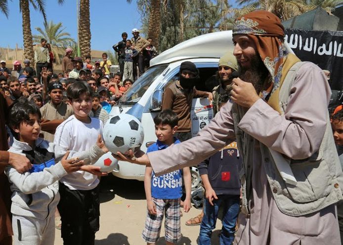 Een IS-gelieerde website verspreidde in januari 2015 deze foto waarop een aanhanger van Islamitische Staat in Raqqa voetballen uitdeelt aan kinderen. Naar schatting verblijven nog 162 kinderen met een Belgische link in Syrië en Irak, van wie er 149 jonger dan 12 jaar zijn en ongeveer 80 procent ter plaatse is geboren.