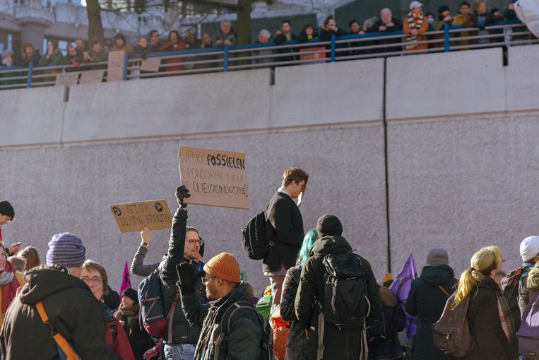 Klimaatactivisten blokkeren de A12 in Den Haag, gesteund door een paar duizend demonstranten die vanaf de rand van de tunnelbak toekijken.  Beeld Fenna Jensma