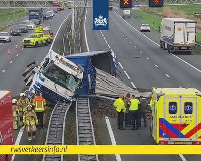 Vrachtwagen kantelt bovenop vangrails van A27 en verliest lading, veel vertraging richting Breda