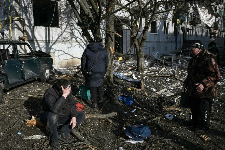 Burgers bij het lichaam van een slachtoffer van een bombardement op Chuguiv nabij Charkov, de tweede grootste stad van Oekraïne in het noorden. Beeld AFP