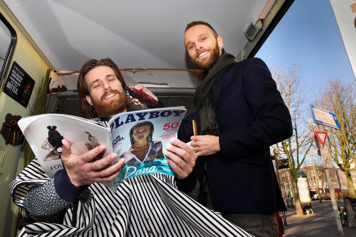 Whiskey, sigaren én mannenbladen. In de bus bij kapper Guillain Baan (rechts) is het een belevenis om geknipt te worden.