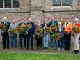 De tien gedecoreerden uit Bronckhorst op de foto met de burgemeester bij de Remigiuskerk.