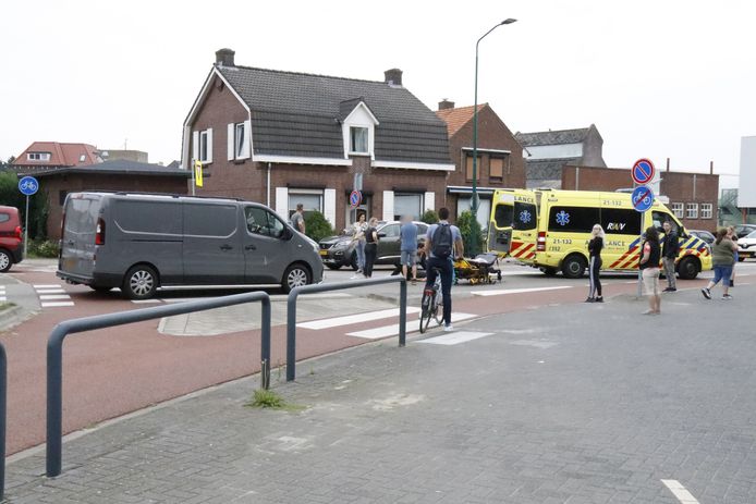 De fietser krijgt eerste hulp na de aanrijding door een bestelbus op de rotonde in Boxmeer.
