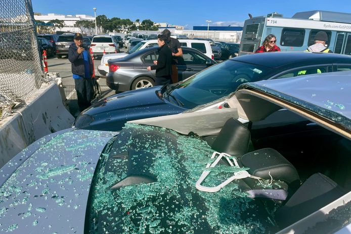 Schade aan een auto op een parkeerplaats voor werknemers van San Francisco International Airport nadat een vliegtuig van United Airlines een verloor tijdens het opstijgen.