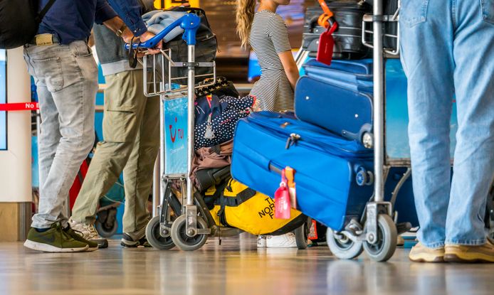 Passagiers slepen heel wat bagage mee op luchthaven Schiphol.