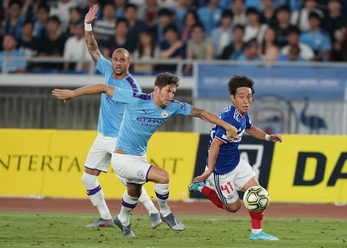 Koji Miyoshi (r) eind juli in Japan tijdens een oefenduel tegen Manchester City en John Stones.