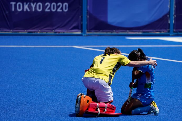 Claire Hinch, de keeper van de hockeysters van Groot-Brittannië, troost Neha Neha van India.