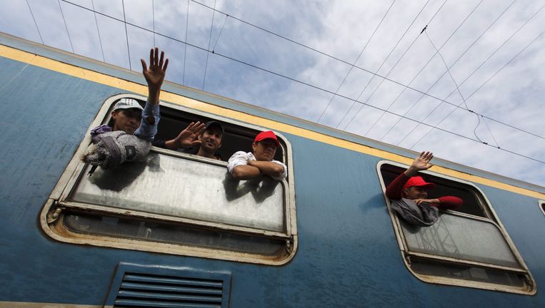 Vluchtelingen zwaaien uit het raam van een trein in Zakany, Hongarije Beeld epa