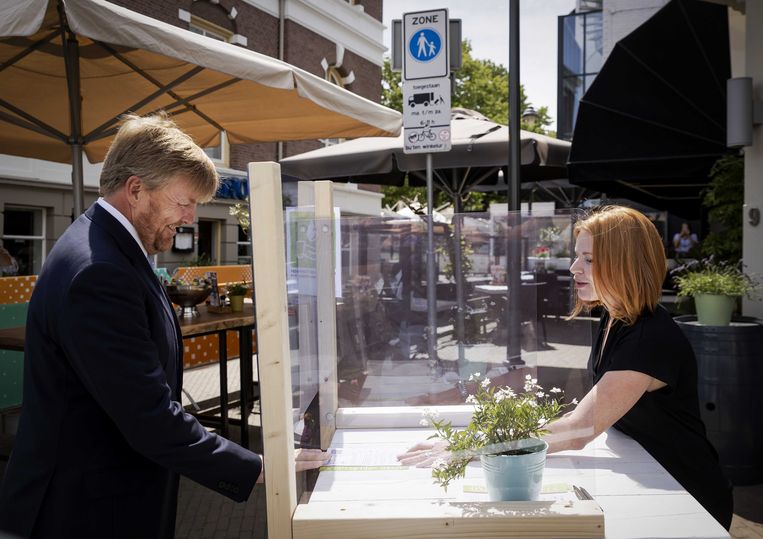 Koning Willem-Alexander praat in juni dit jaar met een horeca ondernemer bij een intake van een terras tijdens een bezoek aan de gemeente Apeldoorn. Beeld ANP