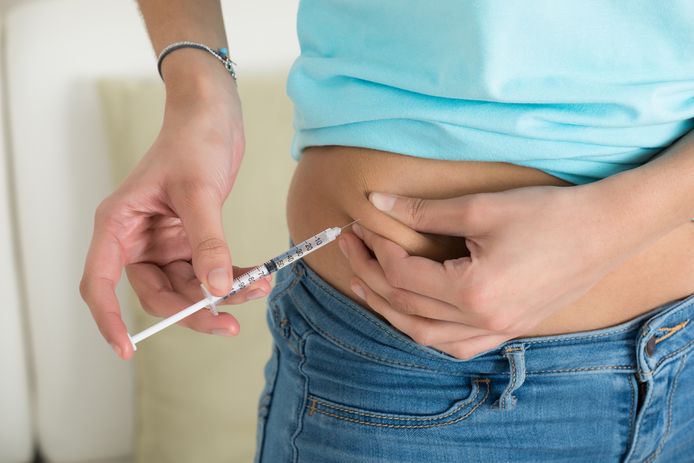 Een vrouw die lijdt aan diabetes spuit insuline in haar lichaam. De insuline zorgt ervoor dat suikers in het bloed kunnen worden omgezet in energie.