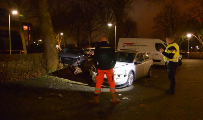 De politie maakt foto's van de gecrashte Audi (l) en een andere geraakte auto.