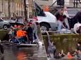 Volle boot zinkt in gracht in Amsterdam tijdens Koningsdag