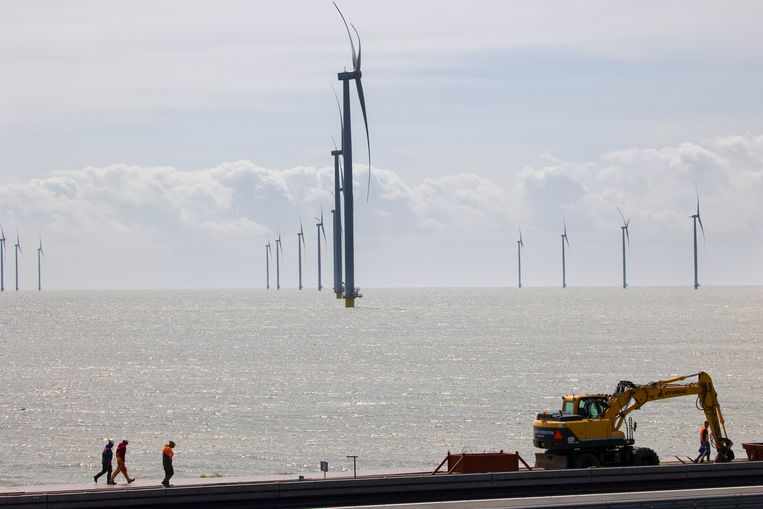 Werknemers op de Afsluitdijk, op de achtergrond de windmolens in het IJsselmeer.
 Beeld Arie Kievit