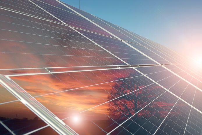 stockadr zonnepanelen zonne-energie Solar battery with reflection of orange sunset with tree on clear blue sky with highlight background, horizontal picture