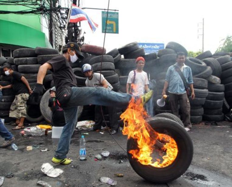 Roodhemden verbranden autobanden op 18 mei om te voorkomen dat het Thaise leger door de barricaden breekt. ANP Beeld 