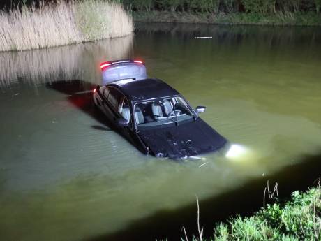 Automobilist komt na botsing lichtmast in het water terecht