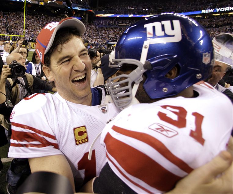 Quarterback Eli Manning van de New York Giants en zijn teamgenoot Justin Tuck vieren hun overwinning. Beeld ap