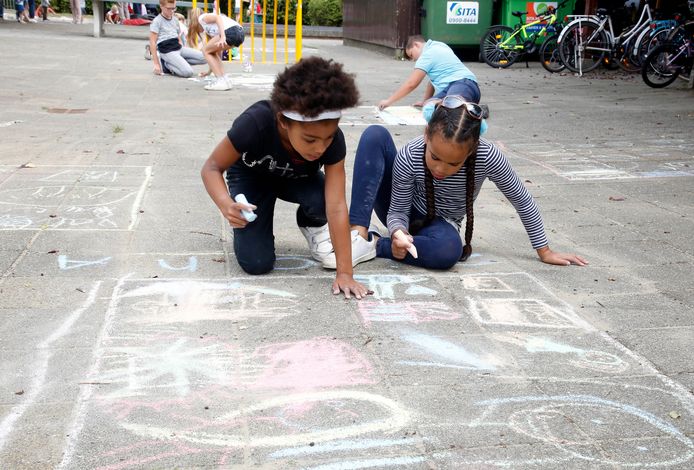 Ziona  (links) en Aliya tekenen de kermis van Nieuw-Namen op het schoolplein.