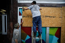 Inwoners van New Orleans timmeren planken op hun huizen om ze te beschermen tegen oprukkend water.