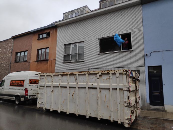 De werkmannen gooien vuilniszak na vuilniszak in de container.