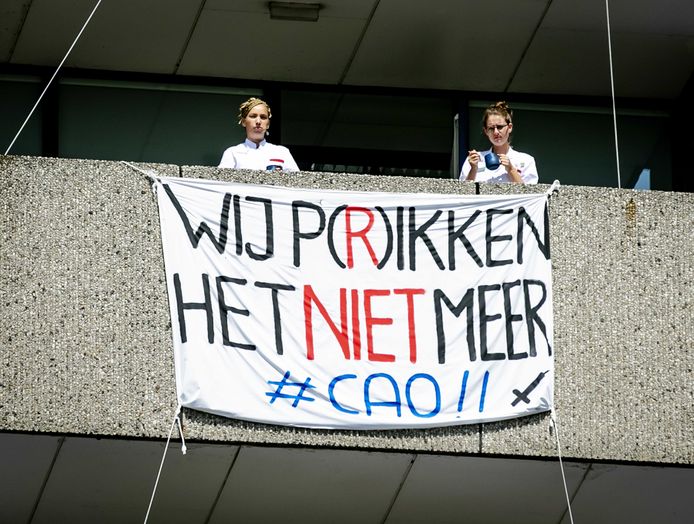Medewerkers van het Onze Lieve Vrouwe Gasthuis in Amsterdam protesteren voor de ingang van het ziekenhuis.