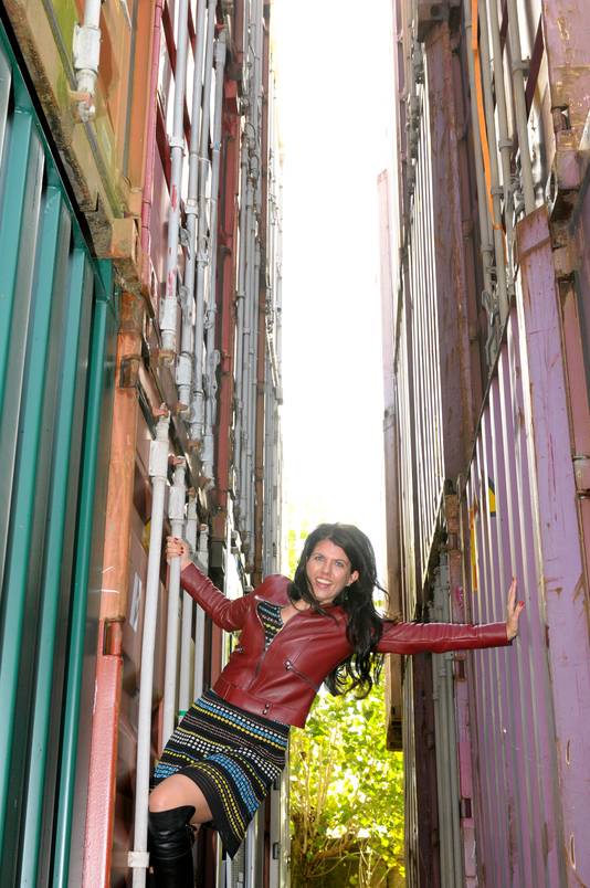 Kristel Groenenboom poseert tussen de containers van haar bedrijf.