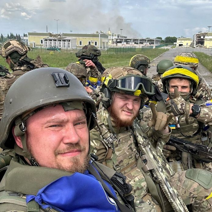 Soldaten van het Russisch Vrijwilligers Korps, een ani-Poetin-militie die onder Oekraïense kleuren vecht, gefotografeerd op 23 mei in de Russische grensstreek Belgorod. De man in het midden die één oog dichtknijpt draagt een Belgische FN-SCAR.