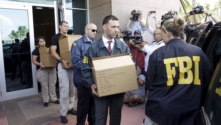 FBI-agenten brengen dozen met mogelijk bewijsmateriaal naar buiten die licht moeten schijnen op de corruptiepraktijken binnen de FIFA. Beeld REUTERS
