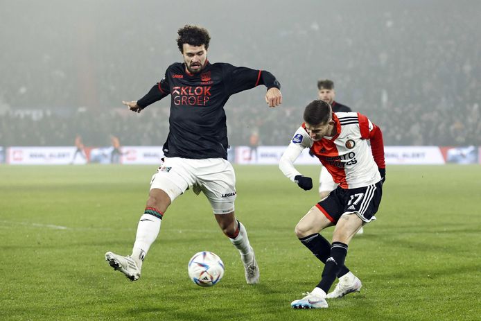 NEC-verdediger Philippe Sandler probeert een voorzet van Feyenoord-middenvelder Sebastian Szymanski te blokken.