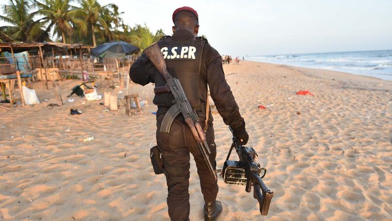 Een soldaat op het strand in Ivoorkust, na de aanslag op een resort op 13 maart. Beeld Afp