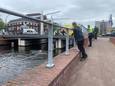 De man laat zich nog niet vangen en zwemt rond in het water vlakbij het gemeentehuis.