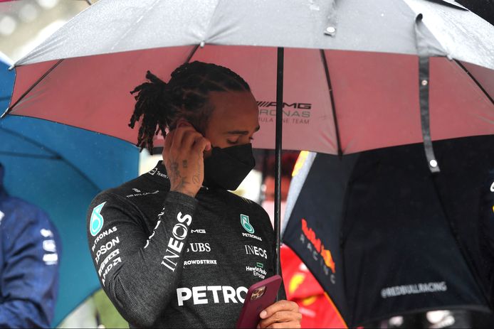 Lewis Hamilton onder een paraplu langs het circuit in Spa.