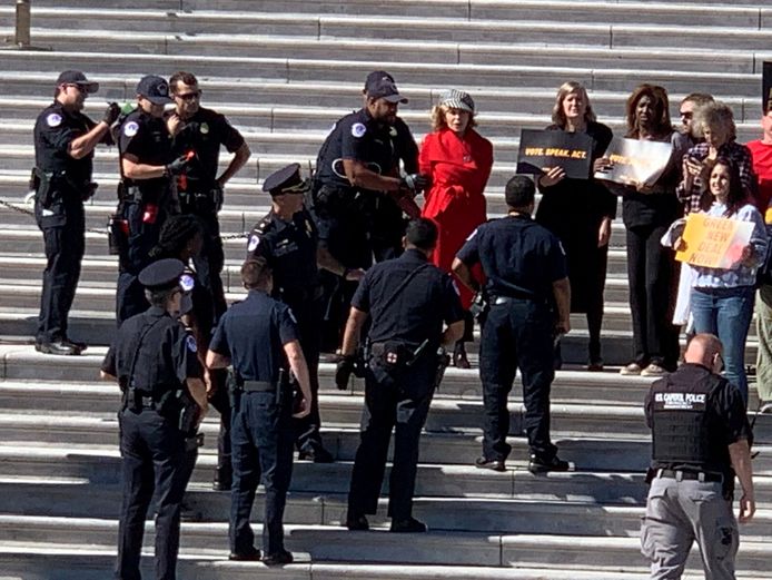 Jane Fonda (in rode jas) wordt gearresteerd
