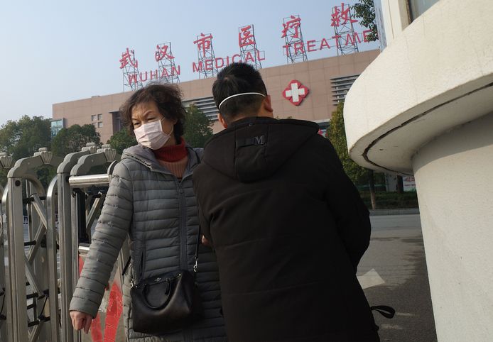 Chinezen bij een ziekenhuis in Wuhan beschermen zich tegen besmetting met het nieuwe coronavirus